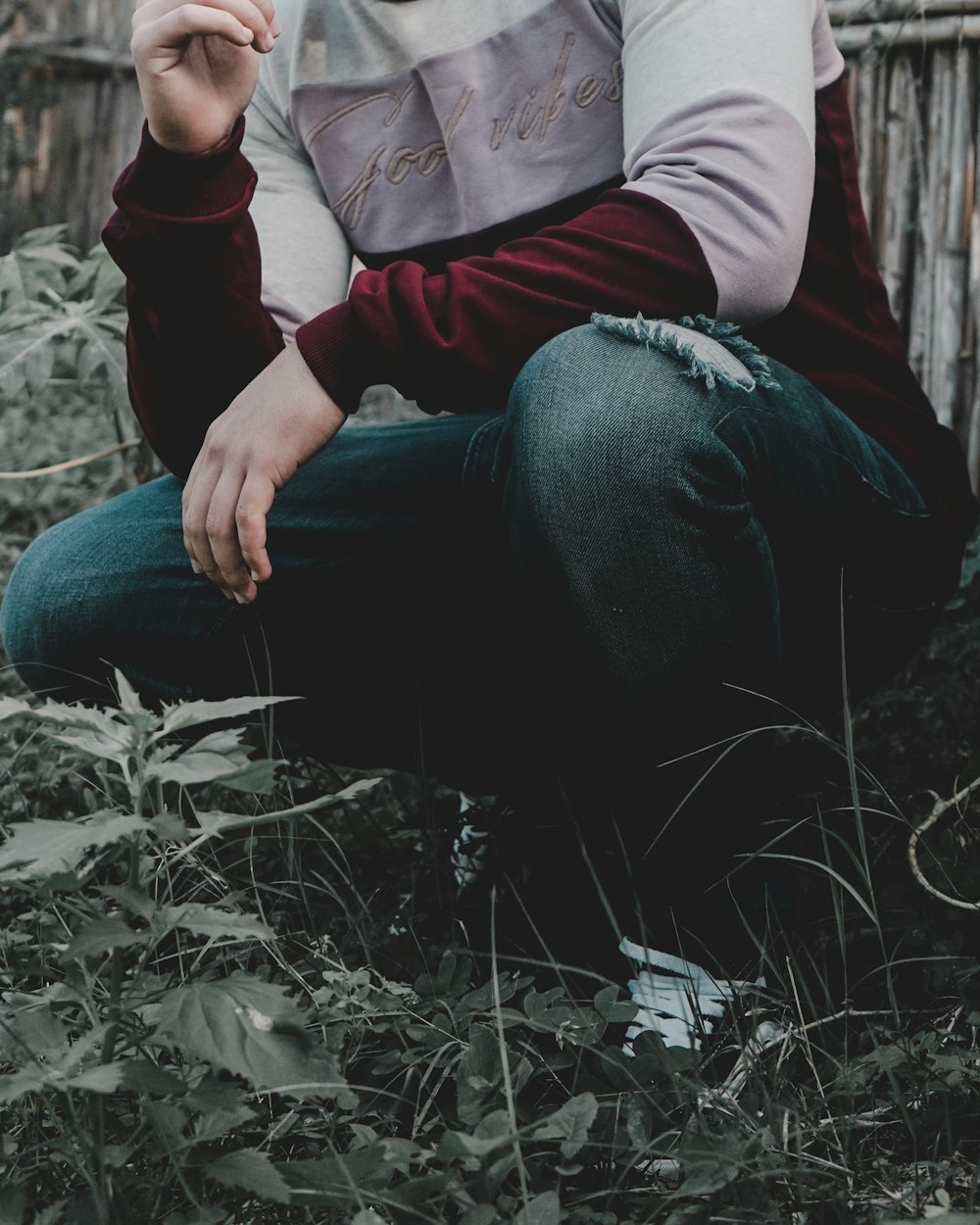 men's black and red sweater and black denim distressed jeans