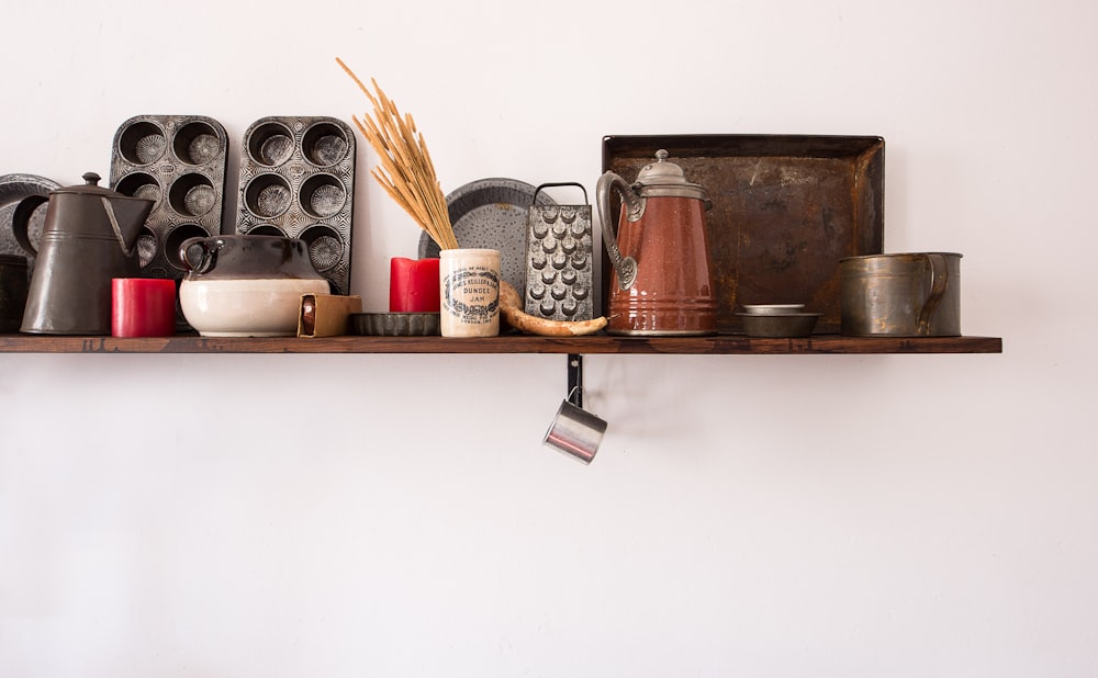 kitchen utensil lot on brown wooden floating shelf