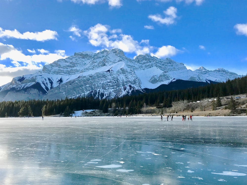 snow coated mountain near body of water