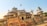 An intricately designed historical building with domes and decorative arches, set against a clear blue sky. Birds are flying around the structure, and a sign in the foreground reads 'Central Museum Jaipur'. The building has detailed architectural elements typical of Indian heritage.