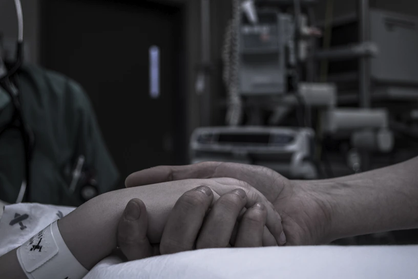 A vibrant photo of a healthcare worker comforting a patient in a hospital room.