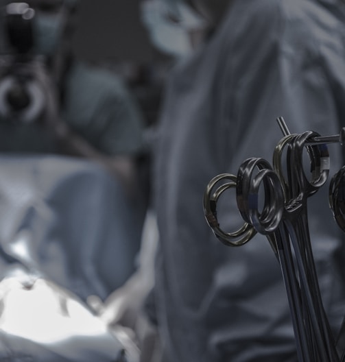 gray surgical scissors near doctors in operating room