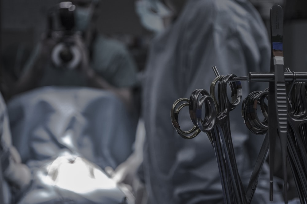 Graue chirurgische Schere in der Nähe von Ärzten im Operationssaal