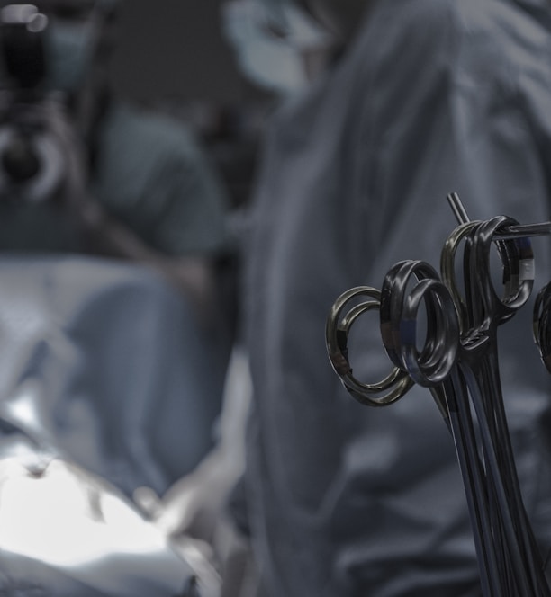 gray surgical scissors near doctors in operating room