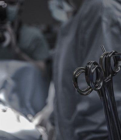 gray surgical scissors near doctors in operating room