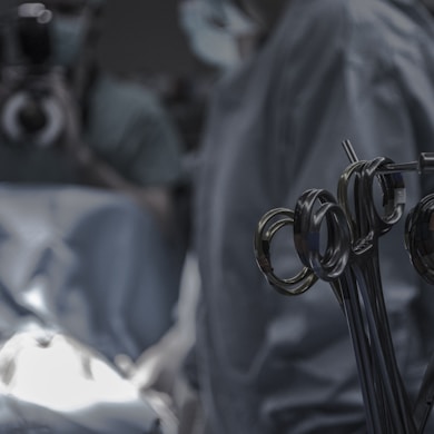 gray surgical scissors near doctors in operating room