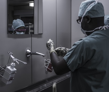 man wearing surgical suit near mirror