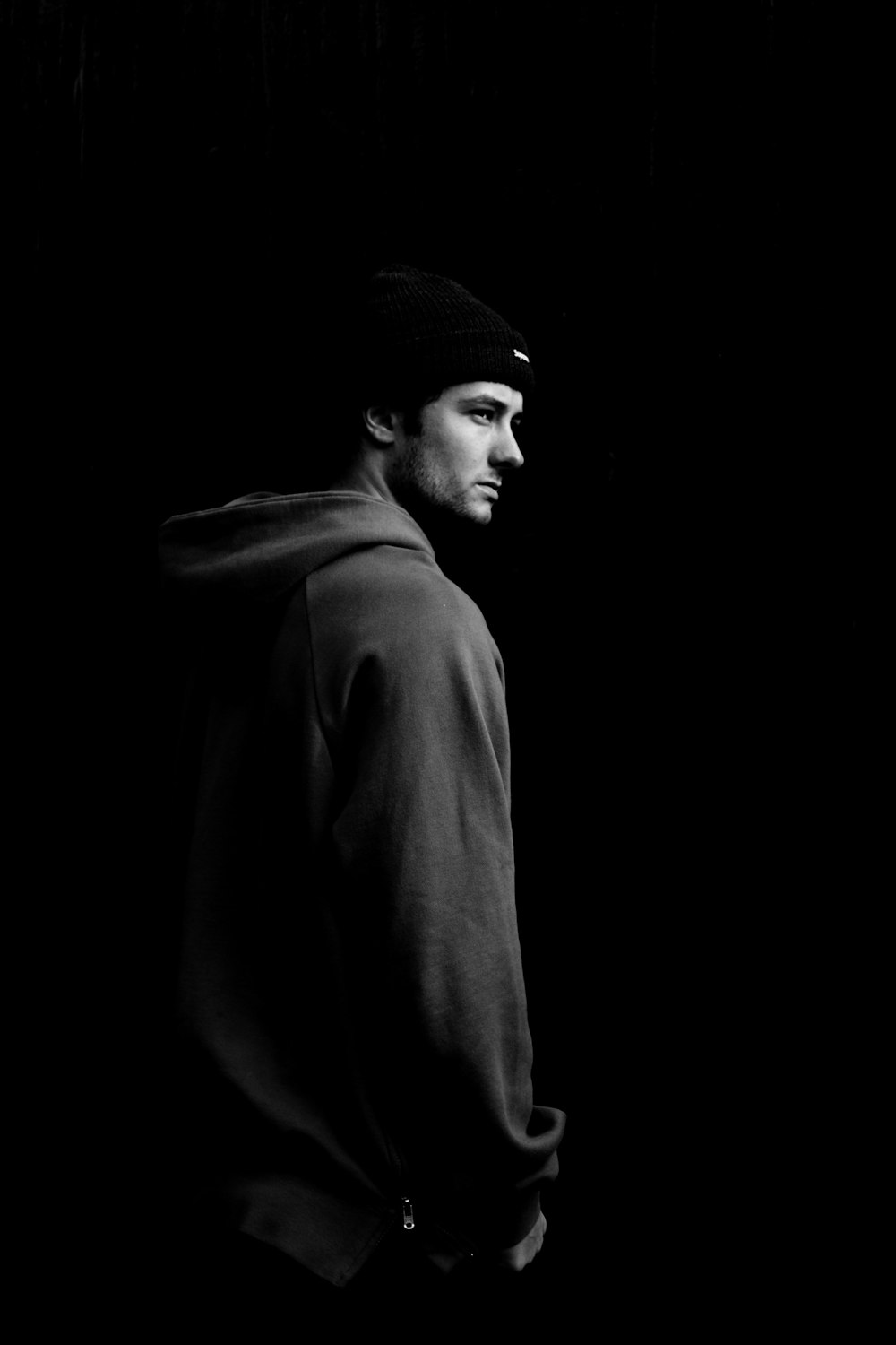 grayscale photo of man wearing hoodie and knit cap