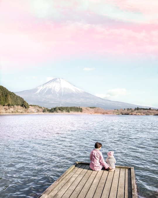 two children sitting on dock in Tanuki Lake Japan