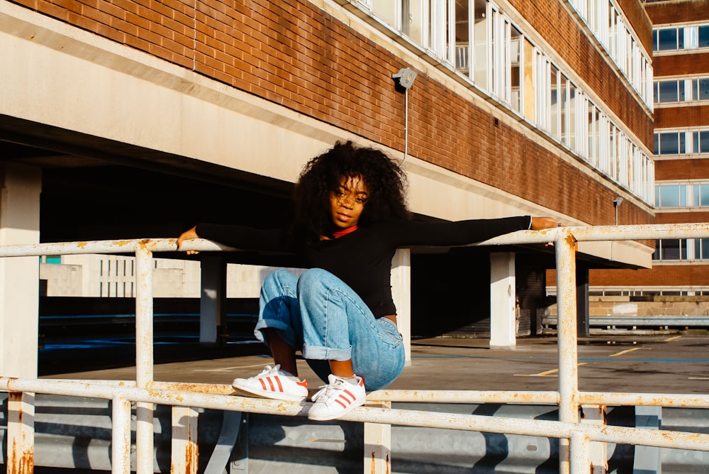 woman sitting on white metal bar