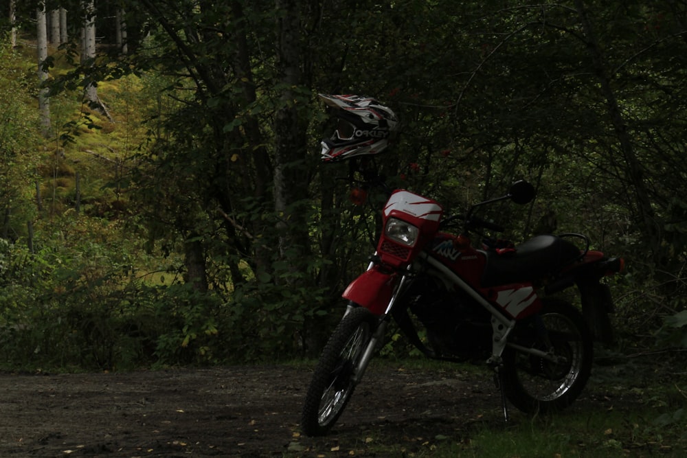 black and white motocross dirt bike surrounded by green trees