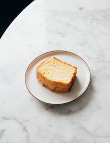 Close-up of a golden sponge cake with a light, airy texture on a rustic plate.