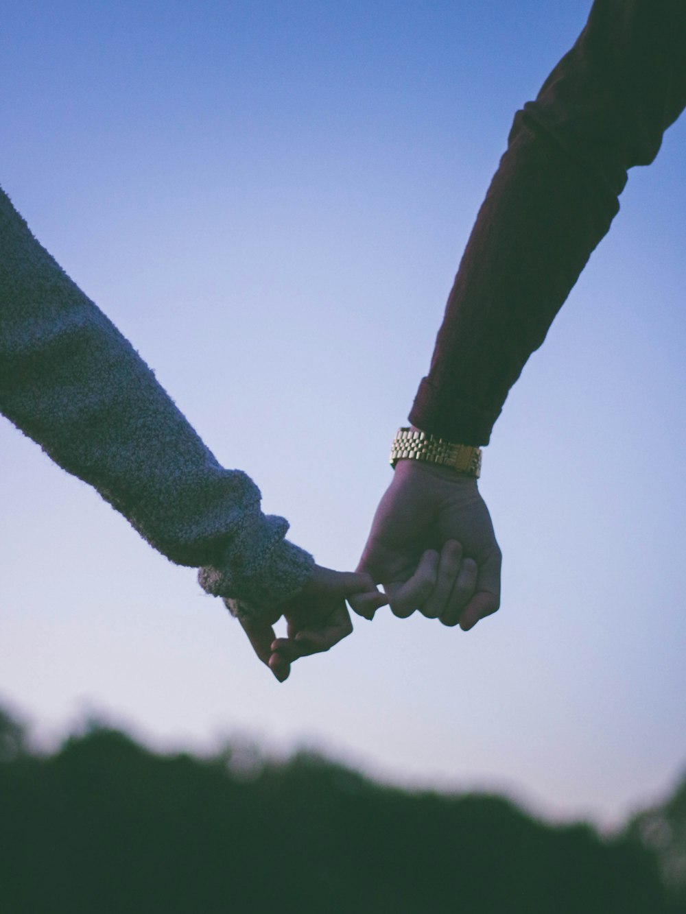 man and woman holding hand using pinky fingers