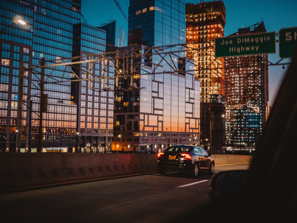 car passing through road beside building