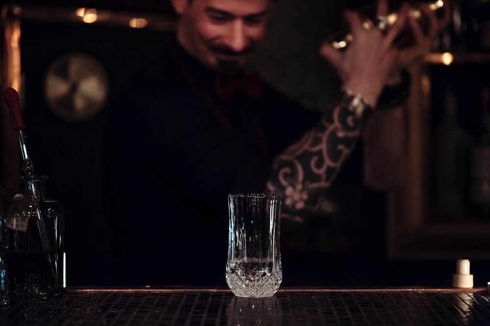 selective focus photography of beer mug in front of man