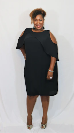 Smiling woman wearing black and yellow outfit, showcasing her aurelia noir jewelry.