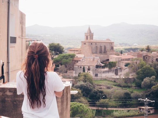 woman standing on terrace facing castle in Girona Spain
