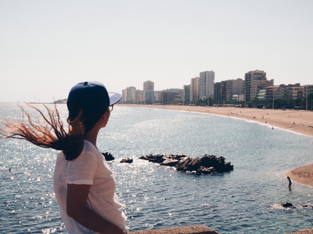 mujer de pie frente a la orilla del mar