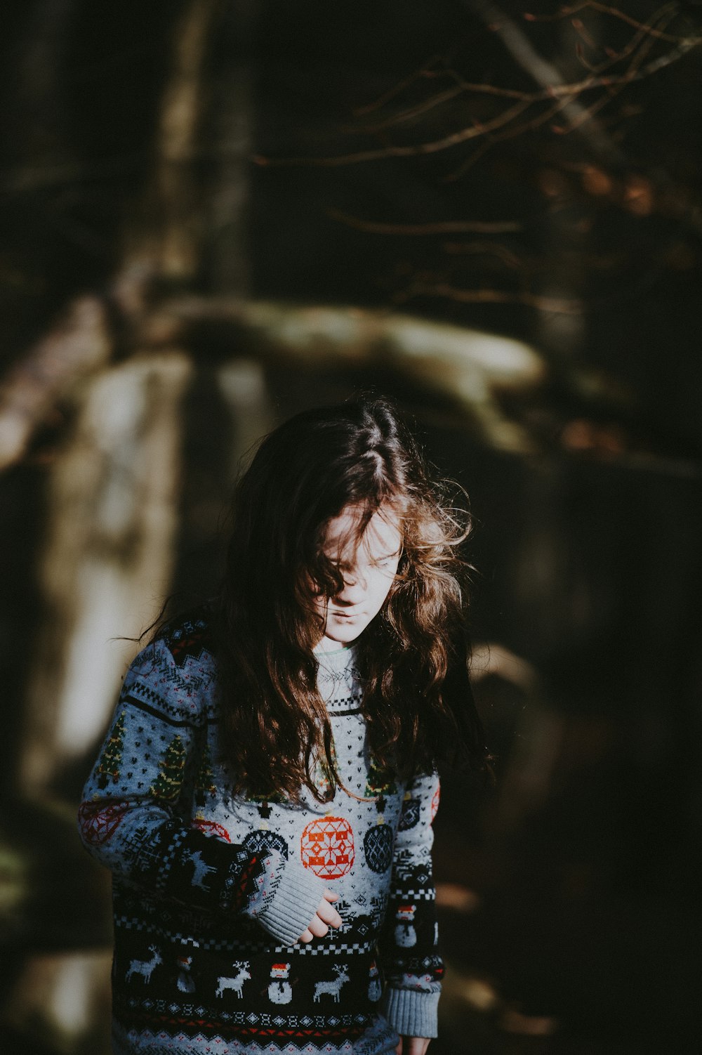 tilt shift lens photography of woman standing near brown tree during daytime