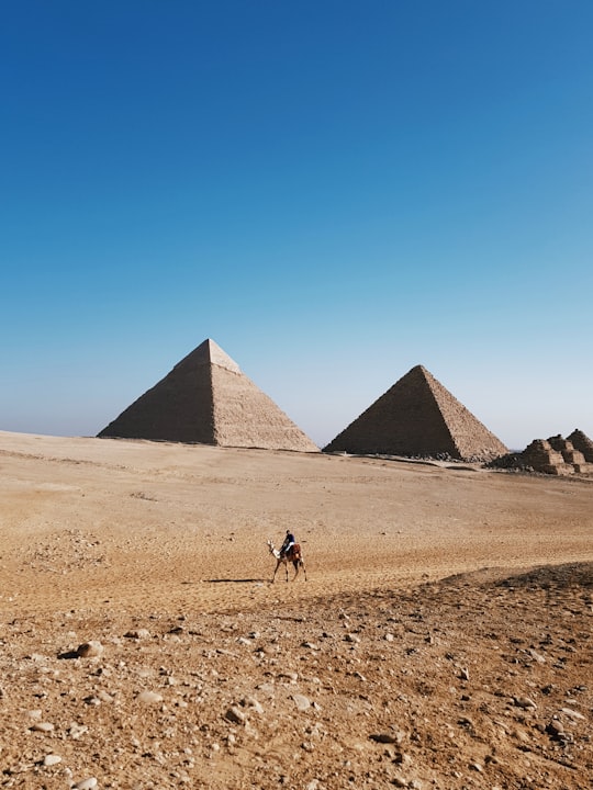 person riding camel during day time in Giza Necropolis Egypt