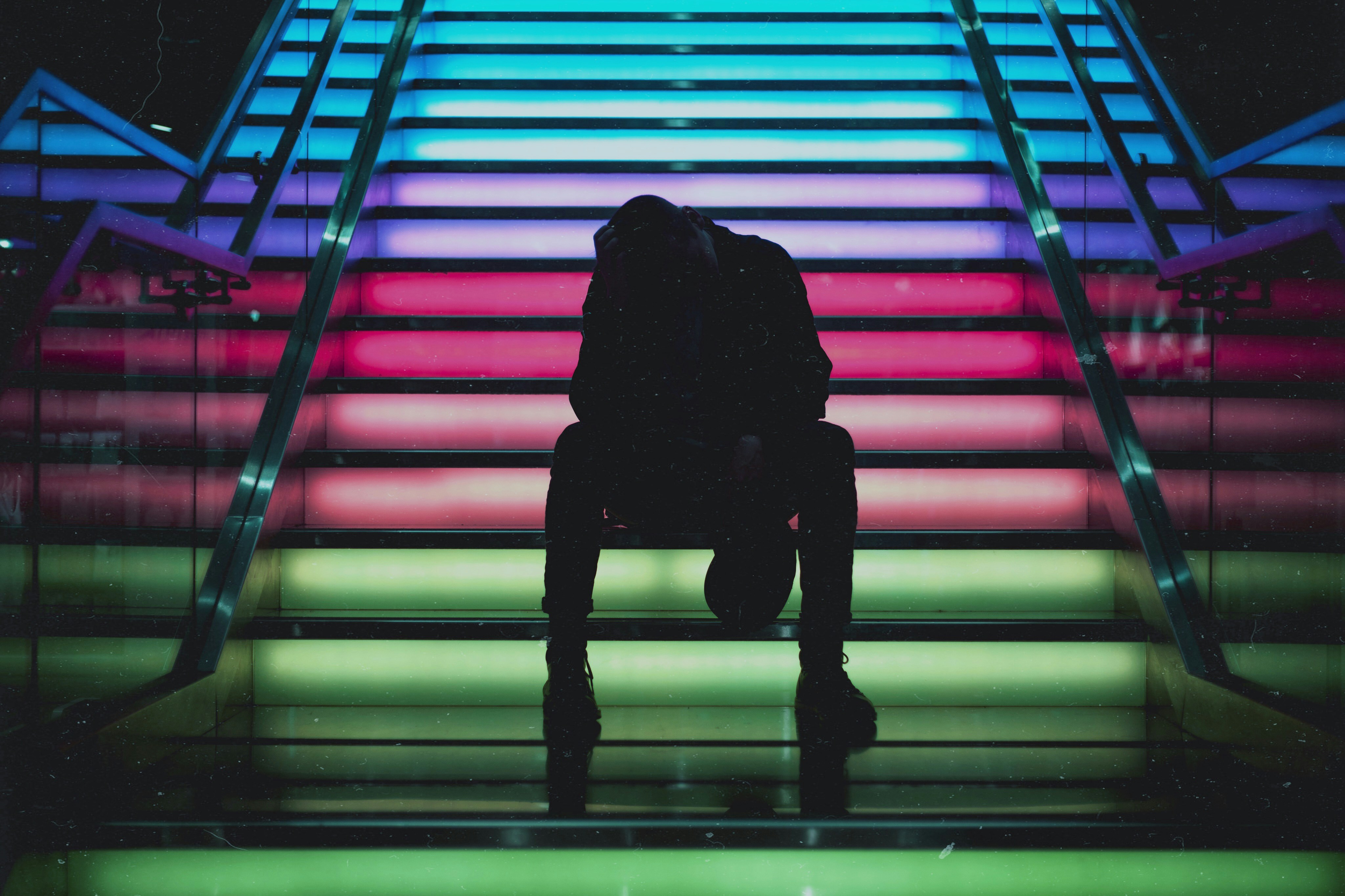 Person sitting on rainbow stairs
