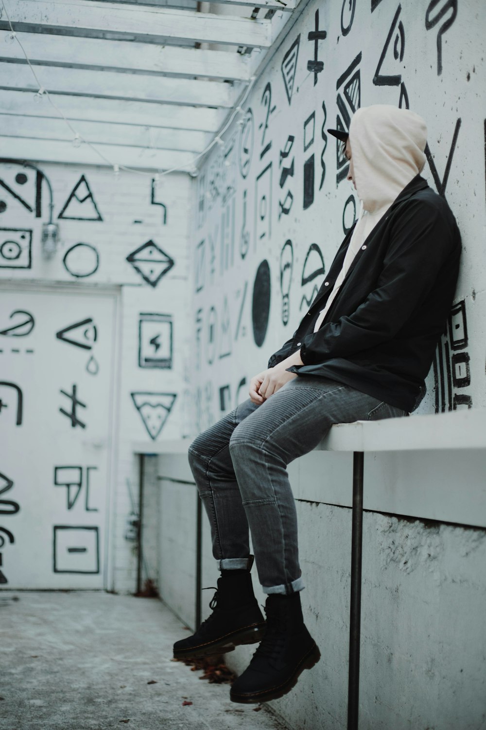 person in black jacket sitting on concrete table