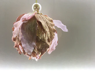 Handmade mobile charms in playful shapes and soft colors, hanging delicately against a blush pink backdrop.