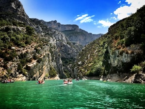 A scenic view of a river with people kayaking and enjoying water sports.