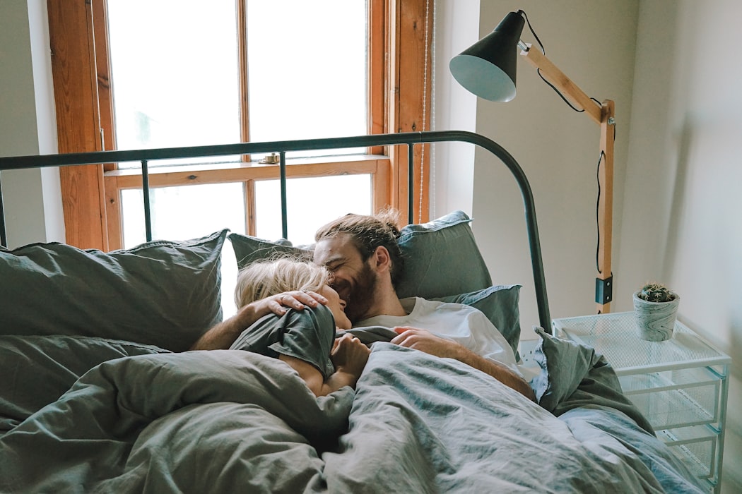 couple cuddling in bed laughing