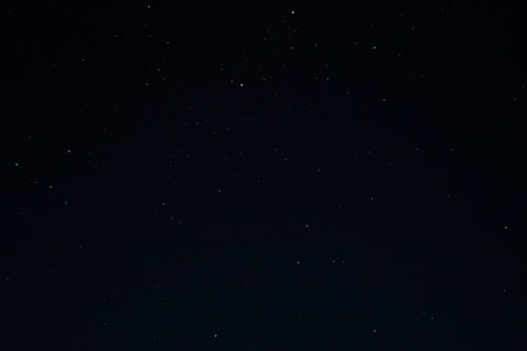 a night sky with stars and a few clouds