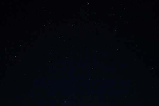 a night sky with stars and a few clouds
