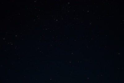 a night sky with stars and a few clouds