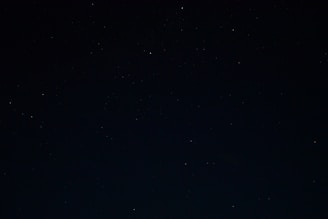 a night sky with stars and a few clouds