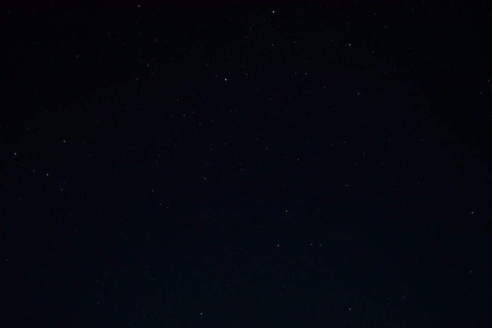 Un cielo nocturno con estrellas y algunas nubes