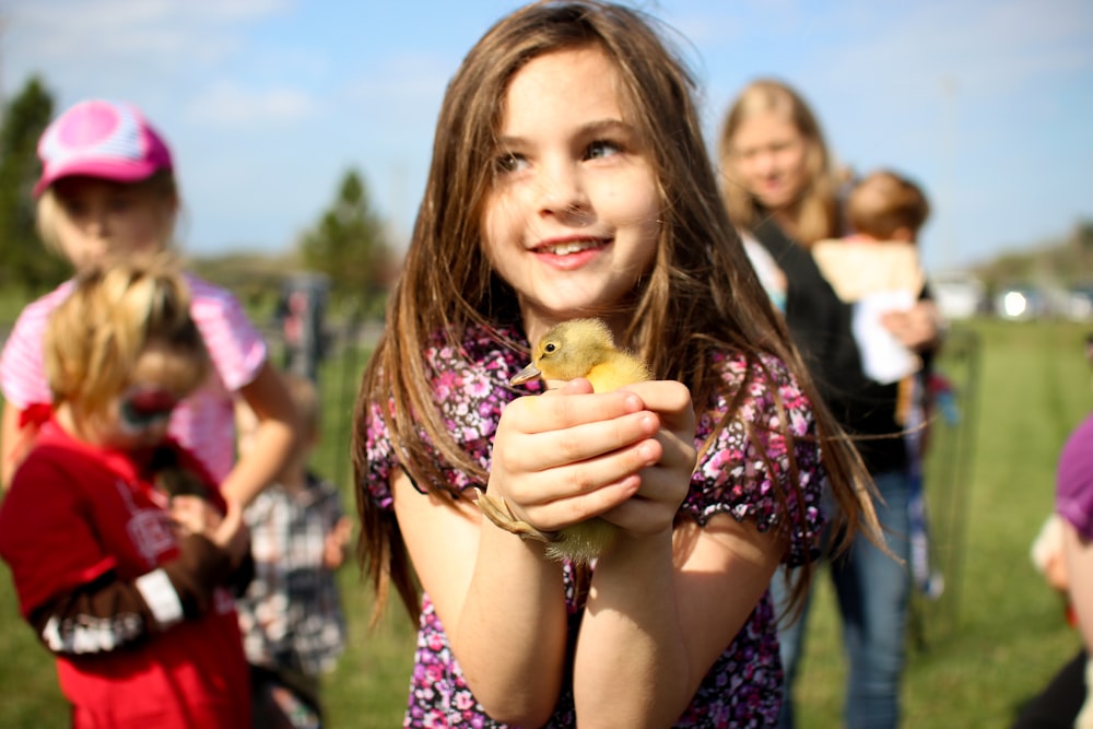 Muchacha sosteniendo patito marrón