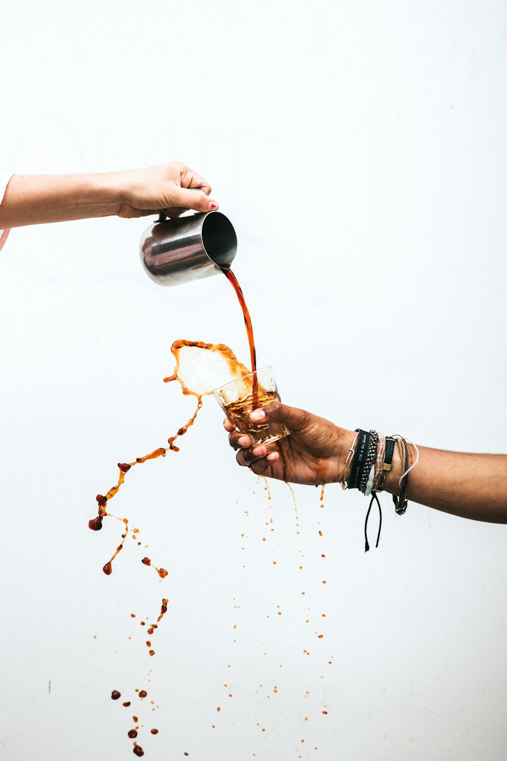 Person, die Kaffee in Glas gießt