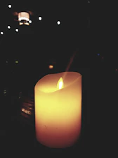 A cozy cream-colored background with softly glowing candles arranged invitingly.