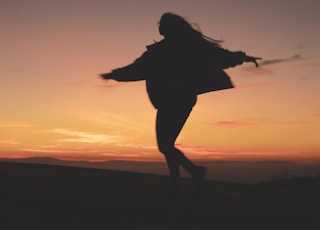 silhouette of woman running during golden hour