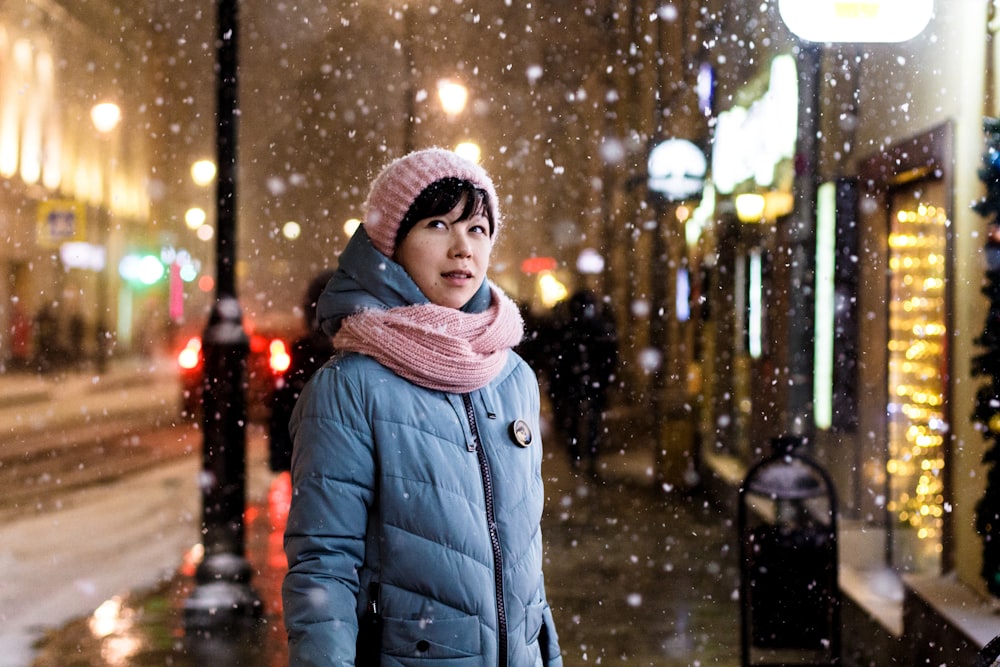 Frau auf dem Bürgersteig in der Nähe von Menschen und Gebäuden im Winter
