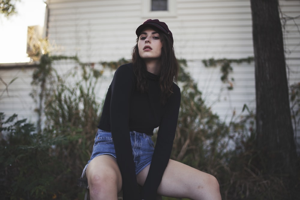 woman sitting on stool near house during daytime