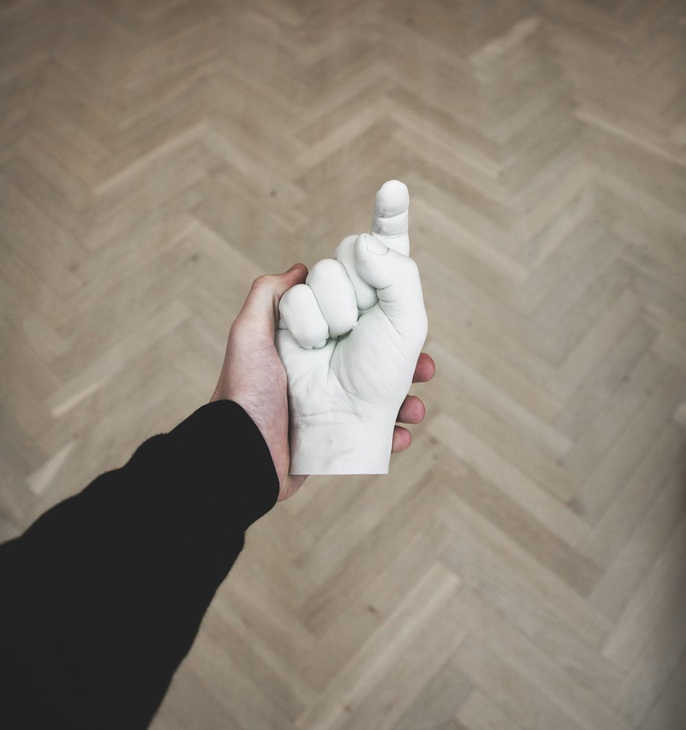 person hand holding hand figurine