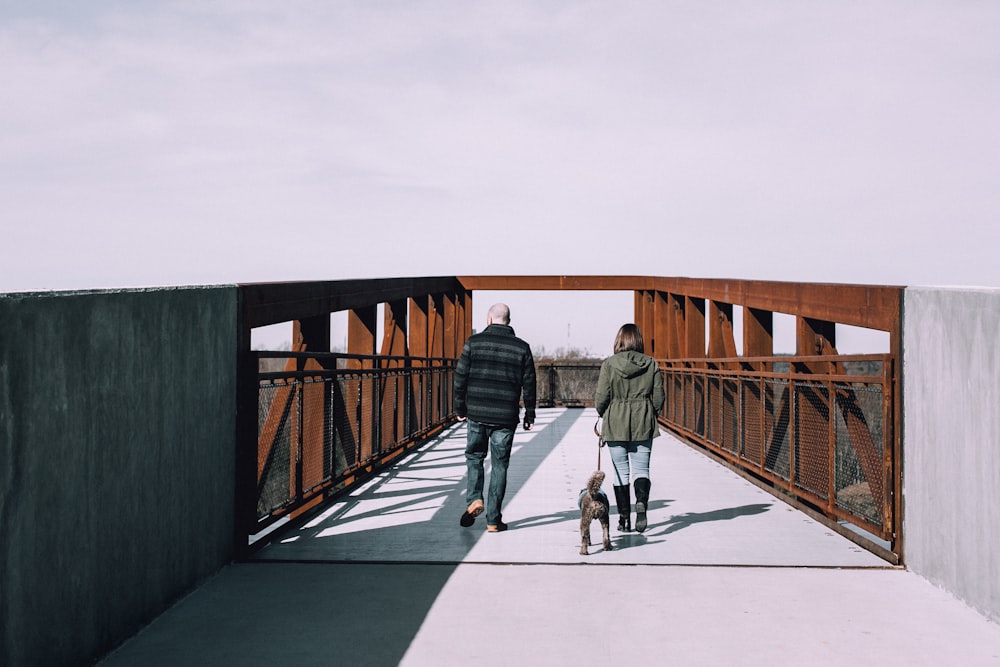 dog, man, and woman about to cross on bridge