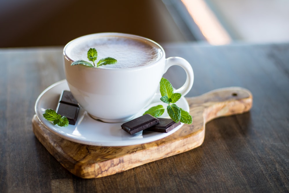 taza de té rellena con barras de chocolate en platillo