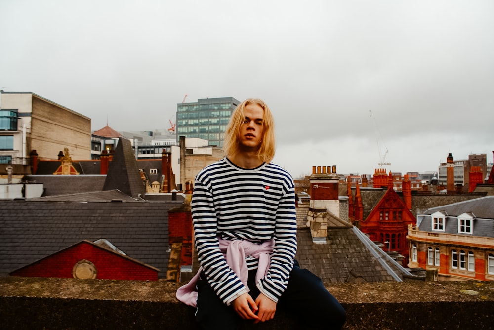 man sitting on roof top fence