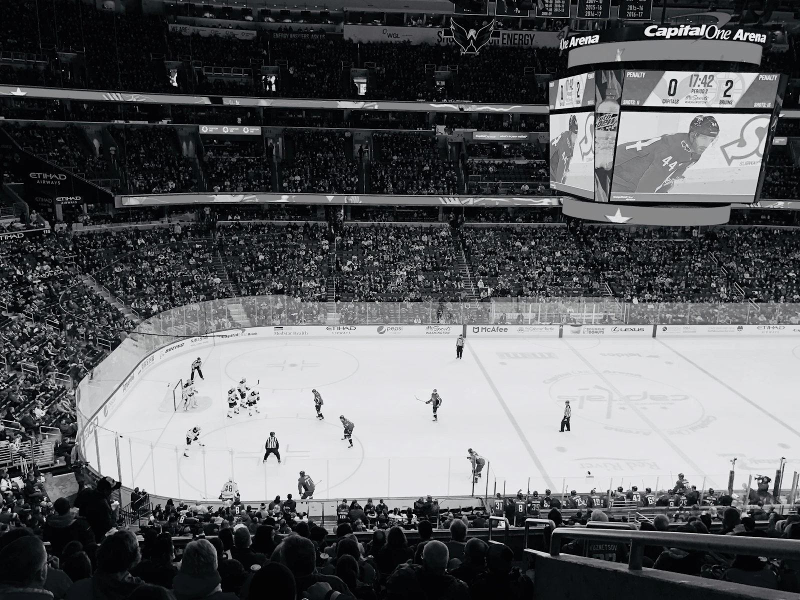 Ice hockey players on the ice inside a packed arena during a game