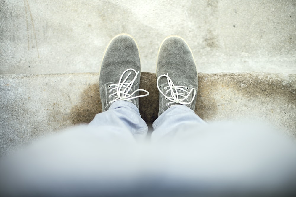 person taking a picture of gray shoes