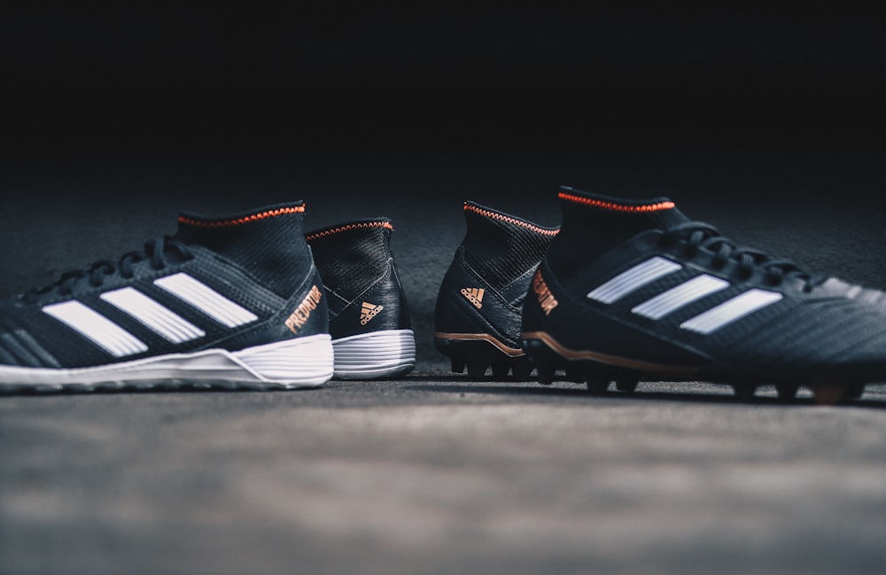 pair of black Adidas cleats