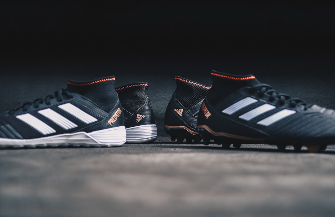 pair of black Adidas cleats,