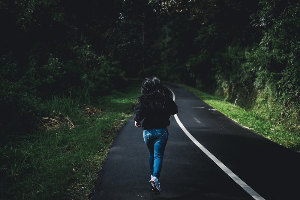 person running towards road during daytime