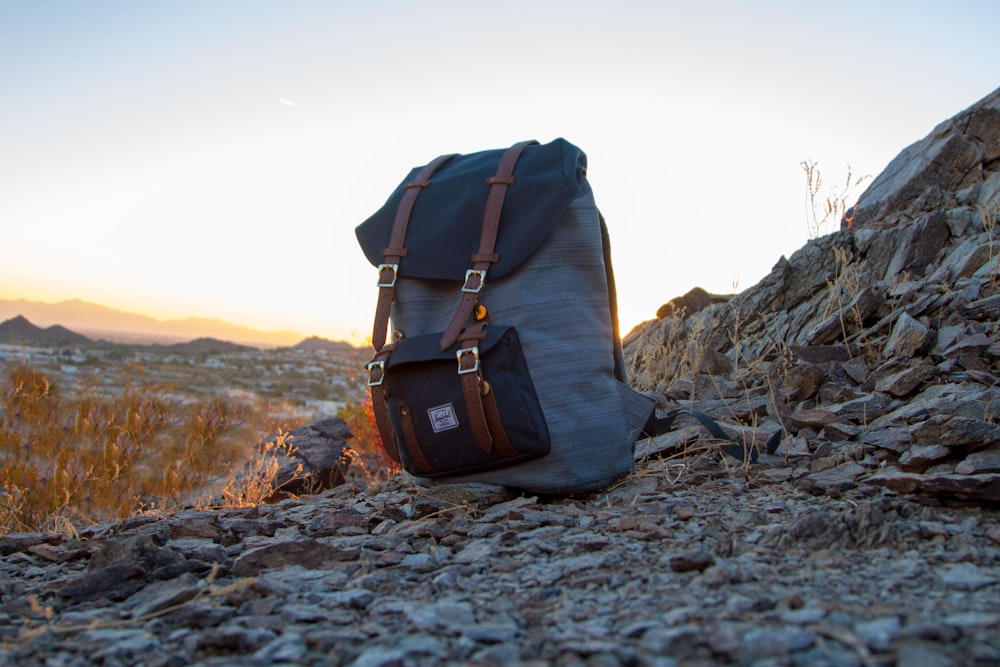 gray and black backpack on top of cliff